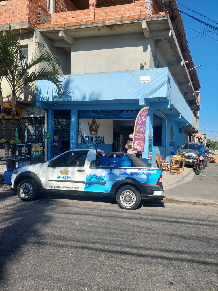 Fachada da loja Água Real Company na Rua Tibúrcio de Sousa nº 348, Itaim Paulista, com a caminhonete de entrega carregada de galões